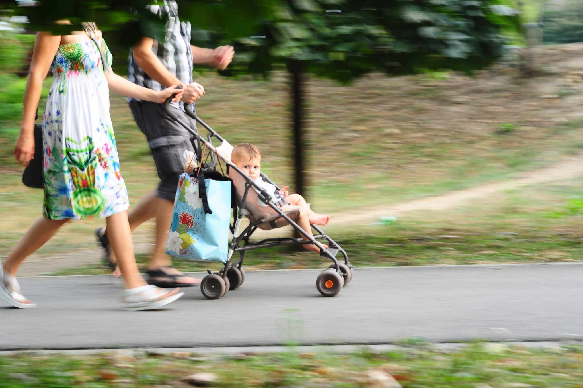 Părinți la plimbare cu copilul în cărucior
